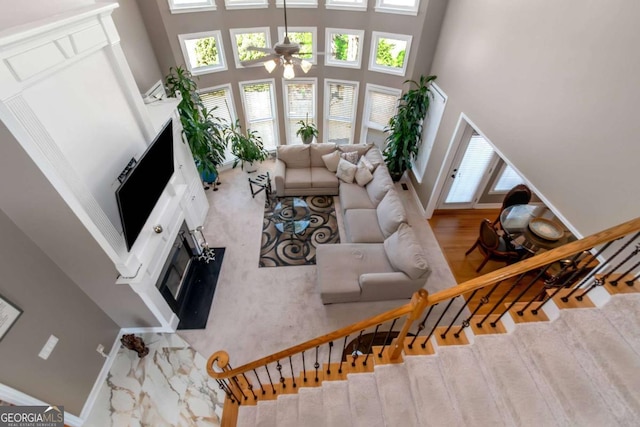 5810 Old Mill Trce, Lithonia, GA 30038 - living area with a towering ceiling, ceiling fan, baseboards, a high end fireplace, and stairs