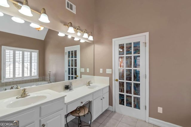 5810 Old Mill Trce, Lithonia, GA 30038 - full bathroom featuring double vanity, tile patterned flooring, a garden tub, lofted ceiling, and baseboards