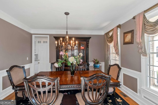 5810 Old Mill Trce, Lithonia, GA 30038 - dining room with a chandelier, a wainscoted wall, plenty of natural light, ornamental molding, and wood finished floors