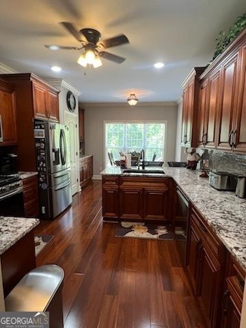 2594 Lassiter Rd, Forsyth, GA 31029 - kitchen with appliances with stainless steel finishes, a sink, crown molding, ceiling fan, and dark wood-style floors