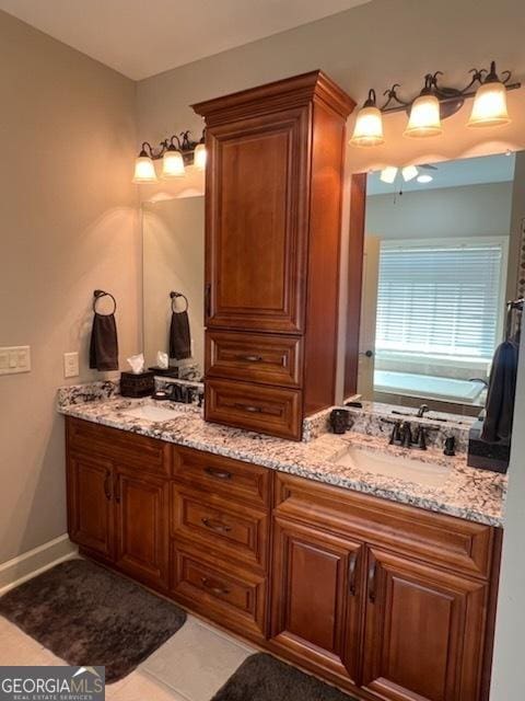 2594 Lassiter Rd, Forsyth, GA 31029 - bathroom with double vanity, baseboards, and tile patterned floors