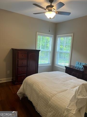 2594 Lassiter Rd, Forsyth, GA 31029 - bedroom with dark wood-style flooring, baseboards, and a ceiling fan