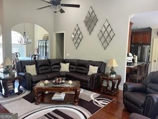 2594 Lassiter Rd, Forsyth, GA 31029 - living area with arched walkways, a chandelier, wood finished floors, and a ceiling fan