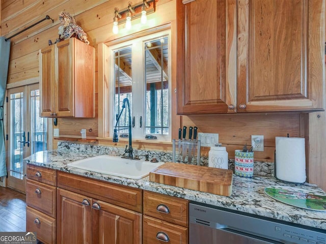 721 Dial Rd, Blue Ridge, GA 30513 - kitchen with stainless steel dishwasher, a sink, brown cabinets, wood finished floors, and light stone counters