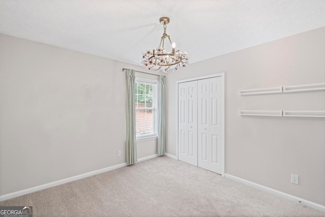 125 Sable Pointe Dr, Milton, GA 30004 - unfurnished bedroom featuring a chandelier, carpet floors, baseboards, and a closet
