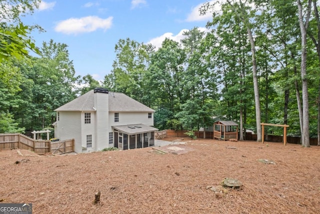125 Sable Pointe Dr, Milton, GA 30004 - rear view of property featuring a sunroom, a chimney, view of scattered trees, and a shingled roof