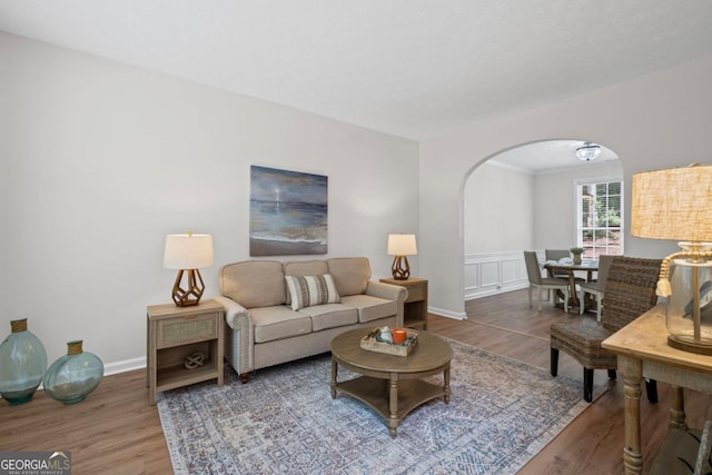 125 Sable Pointe Dr, Milton, GA 30004 - living room with wood finished floors, arched walkways, a wainscoted wall, and baseboards