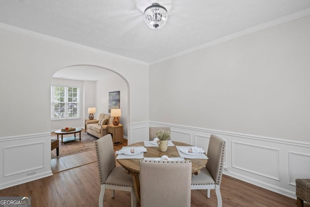 125 Sable Pointe Dr, Milton, GA 30004 - dining space with arched walkways, wood finished floors, wainscoting, ornamental molding, and a decorative wall