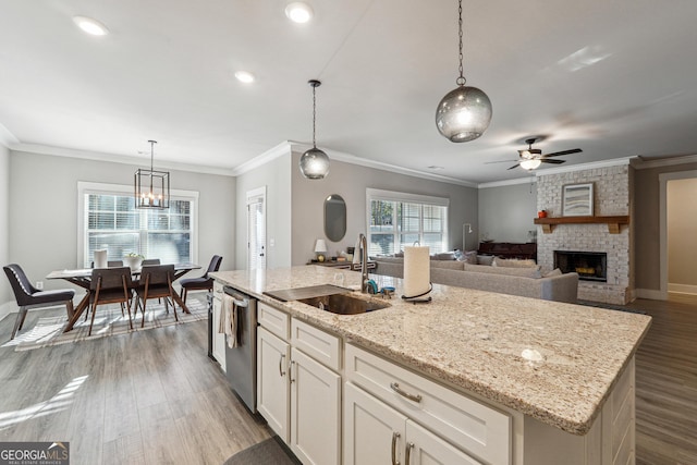 2441 Waterside Dr, Monroe, GA 30655 - kitchen with a sink, stainless steel dishwasher, ceiling fan, a fireplace, and wood finished floors
