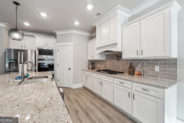 2441 Waterside Dr, Monroe, GA 30655 - kitchen featuring stainless steel appliances, a sink, crown molding, white cabinetry, and decorative backsplash