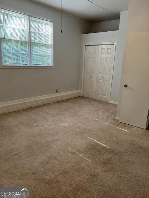304 Tunis Rd, Mcdonough, GA 30253 - unfurnished bedroom featuring light colored carpet, a closet, and baseboards