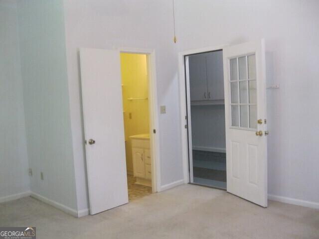 304 Tunis Rd, Mcdonough, GA 30253 - unfurnished bedroom with light colored carpet, ensuite bathroom, a spacious closet, and a closet