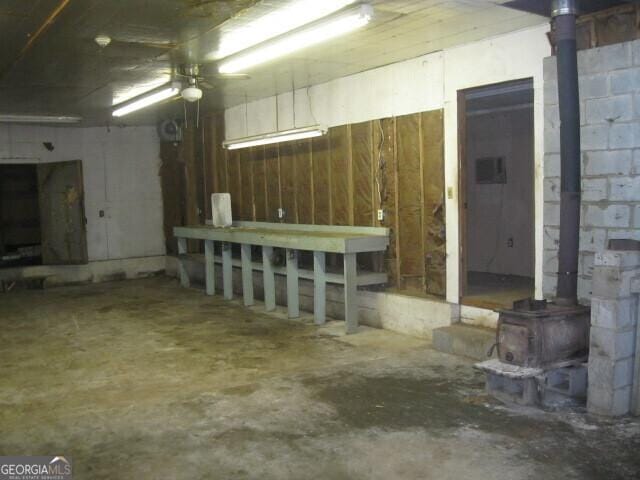 304 Tunis Rd, Mcdonough, GA 30253 - below grade area with a wood stove and a ceiling fan