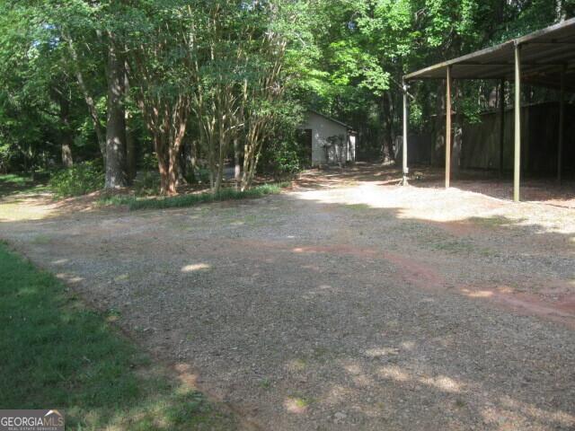 304 Tunis Rd, Mcdonough, GA 30253 - view of yard featuring dirt driveway and a detached carport