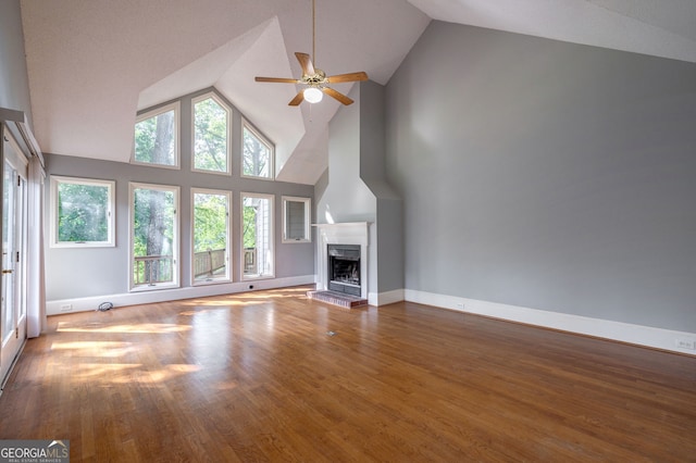 1650 Vintage Club Dr, Greensboro, GA 30642 - unfurnished living room featuring high vaulted ceiling, ceiling fan, a fireplace with raised hearth, wood finished floors, and baseboards