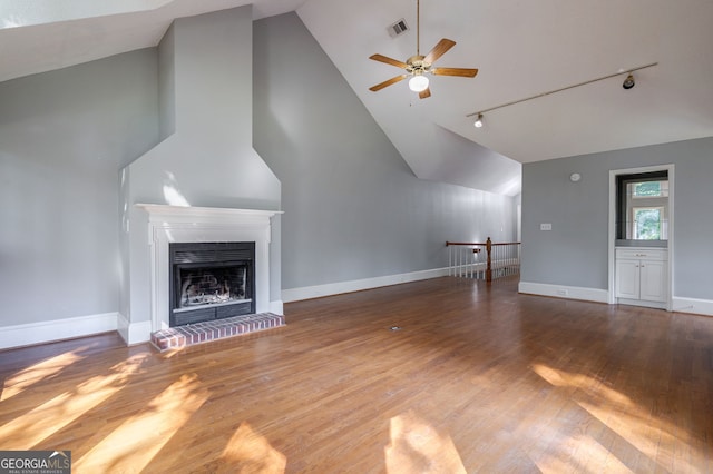 1650 Vintage Club Dr, Greensboro, GA 30642 - unfurnished living room featuring vaulted ceiling, a ceiling fan, track lighting, a fireplace, and wood finished floors