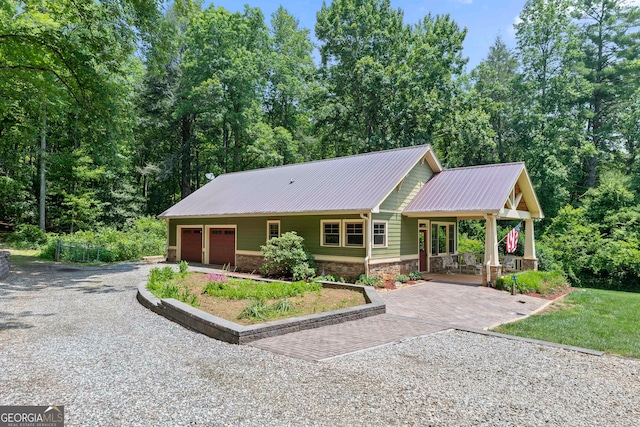1315 Chimney Mountain Flats Trl, Clarkesville, GA 30523 - view of front of home featuring stone siding, covered porch, metal roof, gravel driveway, and a garage