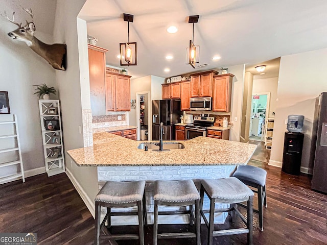 125 Kayla Ct, Locust Grove, GA 30248 - kitchen with appliances with stainless steel finishes, a sink, a peninsula, a kitchen bar, and recessed lighting