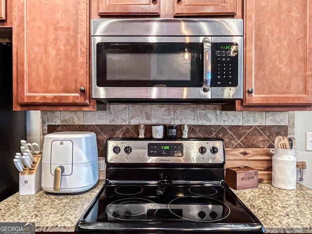125 Kayla Ct, Locust Grove, GA 30248 - kitchen with stainless steel appliances, decorative backsplash, and brown cabinetry