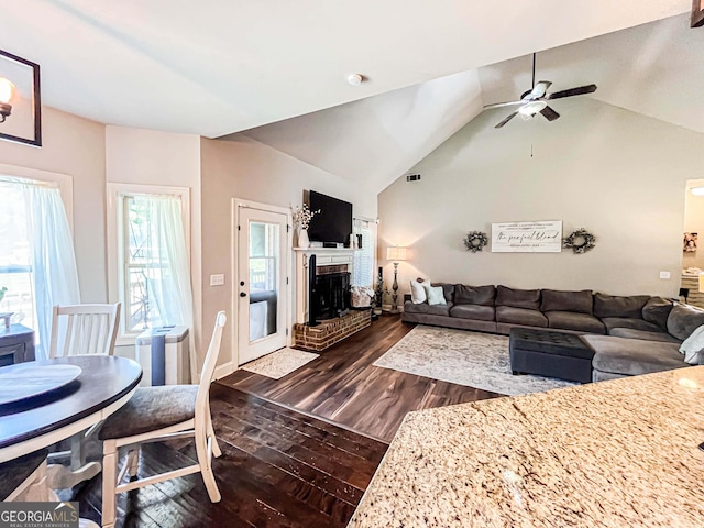 125 Kayla Ct, Locust Grove, GA 30248 - living room featuring dark wood finished floors, ceiling fan, lofted ceiling, a brick fireplace, and baseboards