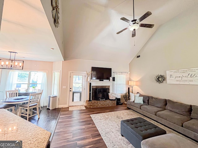 125 Kayla Ct, Locust Grove, GA 30248 - living area with high vaulted ceiling, a ceiling fan, a chandelier, dark wood-style flooring, and a brick fireplace