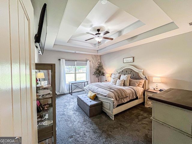 125 Kayla Ct, Locust Grove, GA 30248 - bedroom featuring a tray ceiling, dark carpet, and a ceiling fan