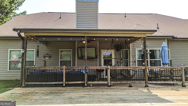 125 Kayla Ct, Locust Grove, GA 30248 - rear view of house featuring a deck, a ceiling fan, a chimney, and roof with shingles