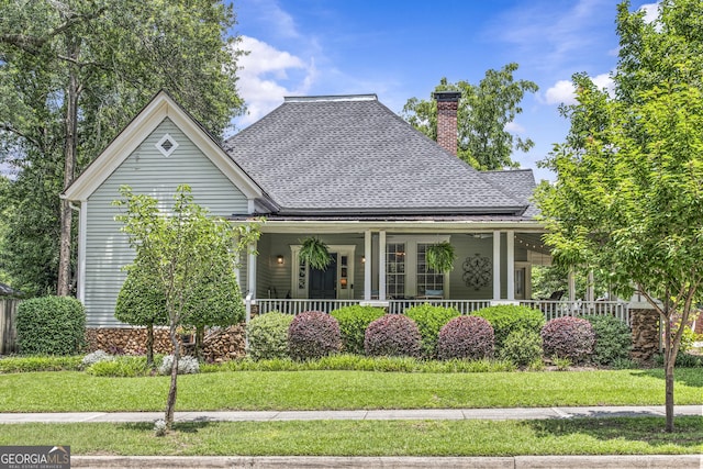 3119 Conyers St SE, Covington, GA 30014 - view of front of home with a chimney, roof with shingles, covered porch, and a front lawn