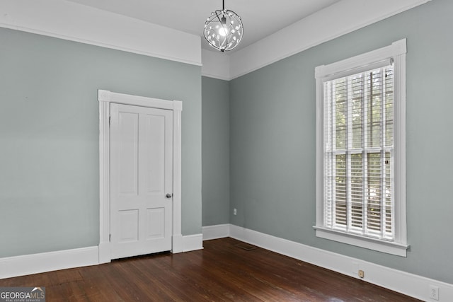 3119 Conyers St SE, Covington, GA 30014 - empty room with wood finished floors, a chandelier, and baseboards