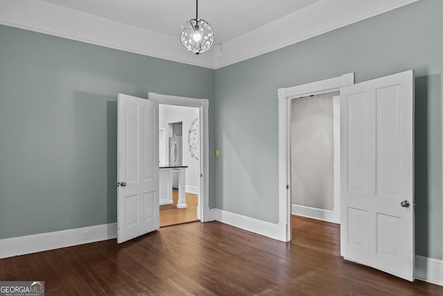 3119 Conyers St SE, Covington, GA 30014 - unfurnished bedroom featuring dark wood-style flooring, baseboards, and a chandelier