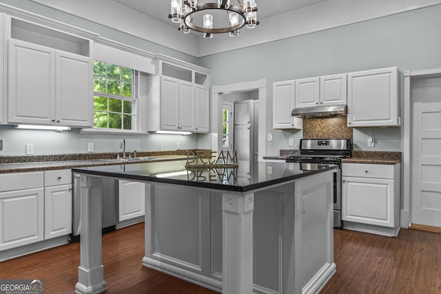 3119 Conyers St SE, Covington, GA 30014 - kitchen featuring appliances with stainless steel finishes, under cabinet range hood, dark countertops, and a chandelier