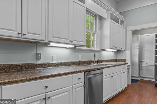 3119 Conyers St SE, Covington, GA 30014 - kitchen with stainless steel dishwasher, dark countertops, a sink, and white cabinetry