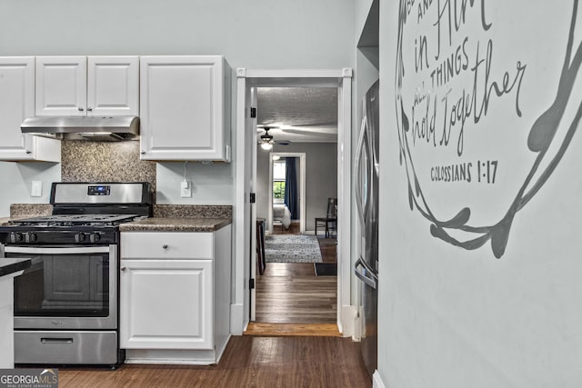 3119 Conyers St SE, Covington, GA 30014 - kitchen with appliances with stainless steel finishes, under cabinet range hood, white cabinetry, dark countertops, and decorative backsplash