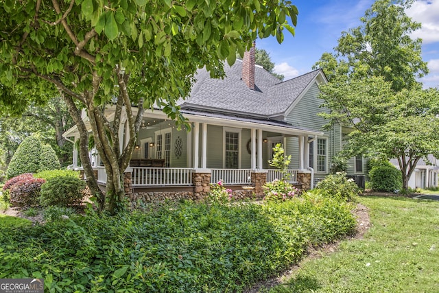 3119 Conyers St SE, Covington, GA 30014 - view of front of house with a shingled roof, a chimney, covered porch, stone siding, and a front lawn