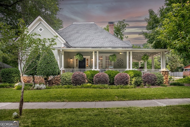 3119 Conyers St SE, Covington, GA 30014 - view of front of house with a porch, a chimney, a front yard, and a shingled roof