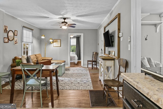 3119 Conyers St SE, Covington, GA 30014 - living room with ceiling fan, wood finished floors, a textured ceiling, crown molding, and baseboards