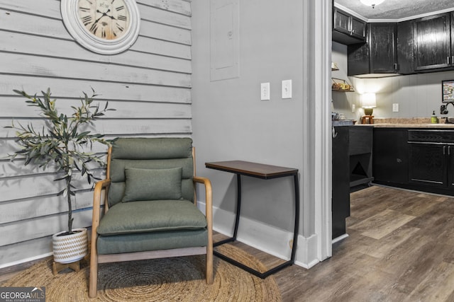3119 Conyers St SE, Covington, GA 30014 - living area featuring dark wood finished floors, bar area, wooden walls, and baseboards