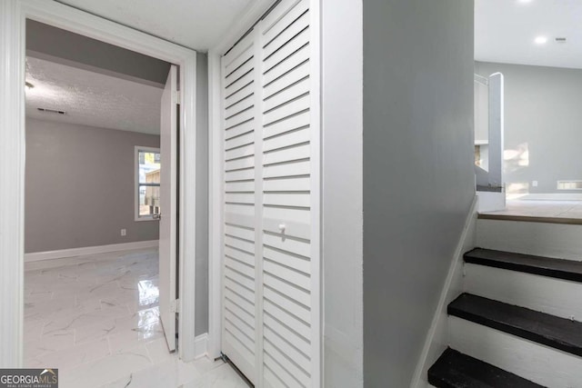 8500 Bowen Ct, Jonesboro, GA 30238 - stairs featuring marble finish flooring, a textured ceiling, and baseboards