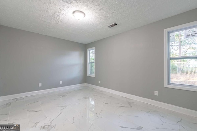 8500 Bowen Ct, Jonesboro, GA 30238 - empty room with light marble finish flooring, baseboards, and a textured ceiling