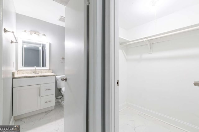 8500 Bowen Ct, Jonesboro, GA 30238 - bathroom with marble finish floors, vanity, a spacious closet, toilet, and baseboards