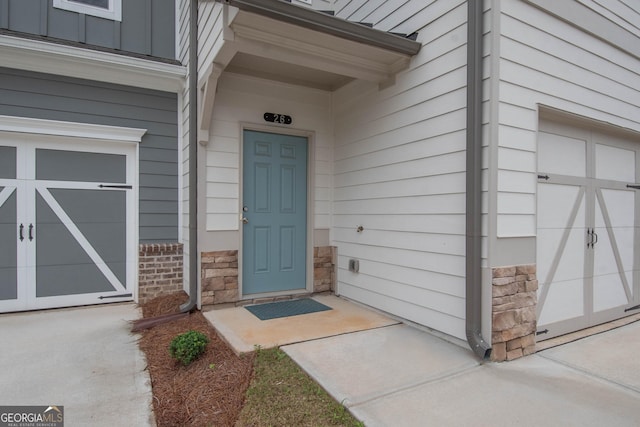 26 Sepia Oak Dr, Newnan, GA 30263 - view of exterior entry featuring stone siding, board and batten siding, and a garage