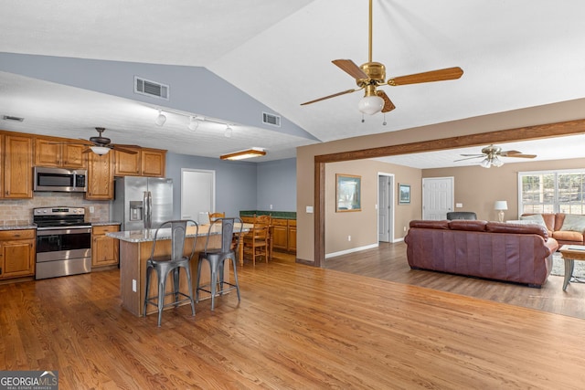 3725 Concord Rd, Newborn, GA 30056 - kitchen featuring appliances with stainless steel finishes, a ceiling fan, a kitchen bar, a center island, and open floor plan