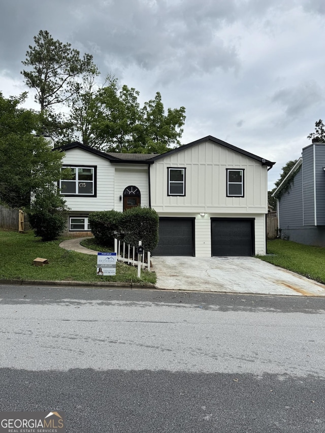 1340 Stoneleigh Way, Stone Mountain, GA 30088 - view of front of house featuring board and batten siding, a garage, driveway, and a front lawn