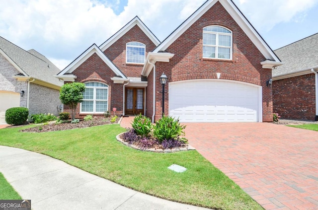 1570 Woodberry Run Dr, Snellville, GA 30078 - traditional-style home featuring brick siding, a front lawn, decorative driveway, and a garage