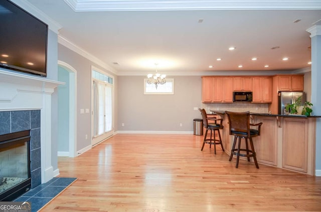 1570 Woodberry Run Dr, Snellville, GA 30078 - kitchen with black microwave, freestanding refrigerator, light wood finished floors, a breakfast bar area, and tasteful backsplash