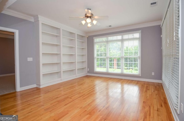 1570 Woodberry Run Dr, Snellville, GA 30078 - empty room featuring ceiling fan, light wood-type flooring, ornamental molding, and built in features