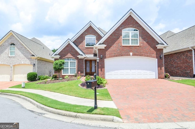 1570 Woodberry Run Dr, Snellville, GA 30078 - traditional-style house featuring brick siding, a front yard, decorative driveway, and an attached garage