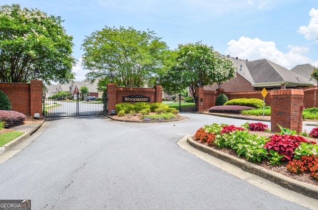 1570 Woodberry Run Dr, Snellville, GA 30078 - view of asphalt road featuring curbs, a gate, and a gated entry