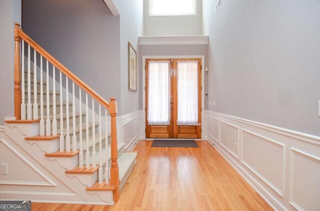 1570 Woodberry Run Dr, Snellville, GA 30078 - foyer entrance with a wainscoted wall, wood finished floors, french doors, a decorative wall, and stairs