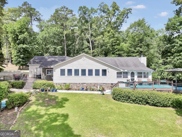 172B Hummingbird Ln, Jackson, GA 30233 - back of property featuring a chimney, a lawn, and a deck